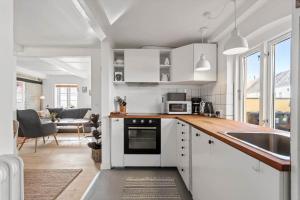 a kitchen with white cabinets and a sink at AE324-Marstal-Kirkestraede-31 in Marstal