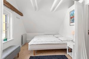 a white bedroom with a bed and a window at AE324-Marstal-Kirkestraede-31 in Marstal