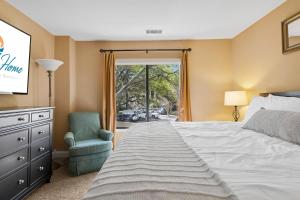 a bedroom with a bed and a chair and a window at 803 Clipper Court in Hilton Head Island