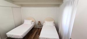 two beds in a room with white walls at ACASADETEO in Padrón +42 photos