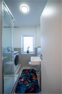 a bathroom with a glass shower and a sink at Helles Apartment in bester Lage in Landshut +8 photos