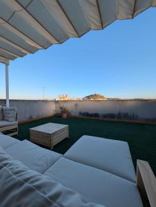 a patio with two beds and a couch and a table at Casa Diego in Alcañiz