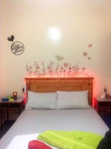 a bedroom with a bed with flowers on the wall at Moroccan Place Private Room in Agadir