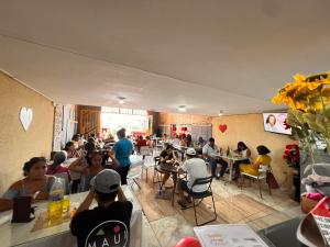 a group of people sitting at tables in a restaurant at Hotel Emmanuel in Chepén