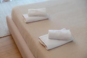 two white towels sitting on top of a bed at Casa Da Luz in Lousada