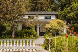 a white house with a fence in front of it at Ironland Roztocze in Ruda Żelazna