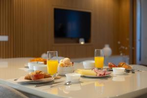 a table with breakfast foods and glasses of orange juice at Casa Da Luz in Lousada