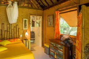 a bedroom with a bed and a window at Charming 1BR Garden Bungalow in Temae