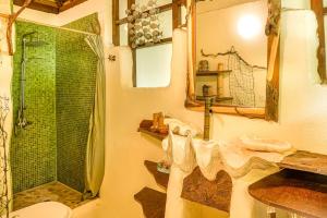 a bathroom with a shower and a toilet and a sink at Charming 1BR Garden Bungalow in Temae