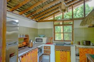 a kitchen with a sink and a microwave at Charming 1BR Garden Bungalow in Temae