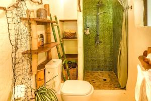 a bathroom with a shower and a toilet and a shower at Charming 1BR Garden Bungalow in Temae +4 photos