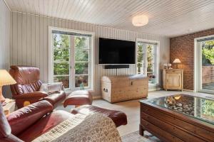 a living room with a couch and a flat screen tv at 2010-Romo-Moritzvej-10 in Høm