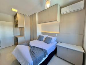 a small bedroom with two beds and a desk at Apartamento com vista mar e perto da praia in Tramandaí