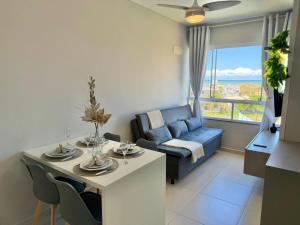 a living room with a blue couch and a table at Apartamento com vista mar e perto da praia in Tramandaí
