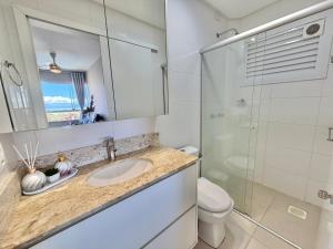 a bathroom with a sink and a toilet and a mirror at Apartamento com vista mar e perto da praia in Tramandaí +17 photos