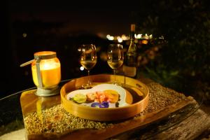 a plate of food and two glasses of wine on a table at Le jardin de Védèze in Les Abymes +21 photos