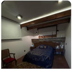 a bedroom with a bed and a red chair at Hotel Boutique Santa Teresa in Tlazcalancingo