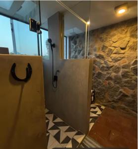 a bathroom with a open door and a stone wall at Hotel Boutique Santa Teresa in Tlazcalancingo