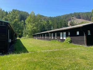 a row of buildings in a field of grass at Wellness & Nature Hostel in Pirkenhammer