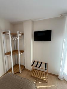 a room with a bed and a tv and a shelf at Pensión el Horno REFORMADO in León