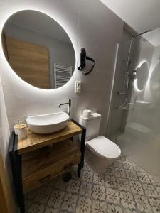 a bathroom with a sink and a toilet and a mirror at Pensión el Horno REFORMADO in León