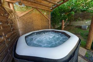a hot tub in a backyard with a pergola at Villa Providencia jacuzzi 1 min plage Le Diamant in Le Diamant