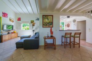 a living room with a couch and a table and chairs at Villa Providencia jacuzzi 1 min plage Le Diamant in Le Diamant