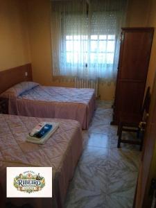 a hotel room with two beds with a sign on it at Hostal Ribeiro Verín in Verín +1 photo