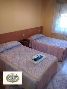 a hotel room with two beds with a sign on it at Hostal Ribeiro Verín in Verín