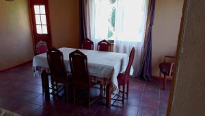 a dining room with a table and chairs and a window at Chalet yuris in Melipilla