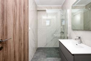 a bathroom with a sink and a shower at MARTINI APARTMENTs MAISONETTE in Nikiti