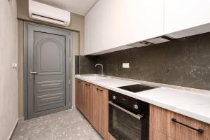 a kitchen with a stove and a sink and a door at MARTINI APARTMENTs MAISONETTE in Nikiti
