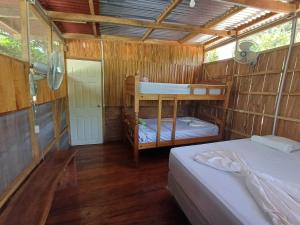 a bedroom with two bunk beds in a wooden house at Cabañas Dilany in Moyogalpa