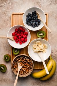 a table with plates of fruit and bowls of nuts at De Roos Leeuwarden Bloementuin & Biodynamisch Ontbijt in Leeuwarden