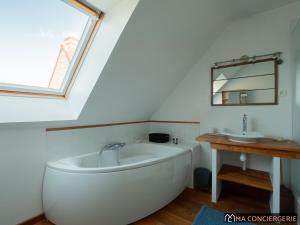a white bath tub in a bathroom with a sink at L'océanne in Équihen-Plage +47 photos