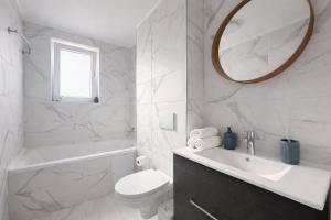 a bathroom with a sink and a toilet and a mirror at Damon Suite #NorthBucharest in Tunari