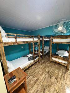 a room with three bunk beds and a table at Pousada JV Para-tí in Paraty