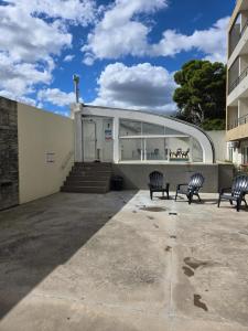 two chairs in front of a building at Casa del Parque estudio 4 pax in Necochea