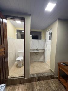 a bathroom with a toilet and a walk in shower at Pousada JV Para-tí in Paraty