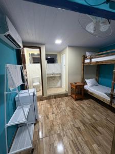 a room with two bunk beds and a bathroom at Pousada JV Para-tí in Paraty