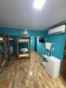 a room with three bunk beds and a refrigerator at Pousada JV Para-tí in Paraty