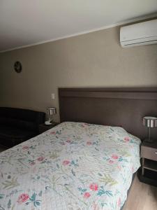 a bedroom with a bed with a floral bedspread at Casa del Parque estudio 4 pax in Necochea