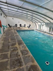 an indoor swimming pool with chairs in a building at Casa del Parque estudio 4 pax in Necochea