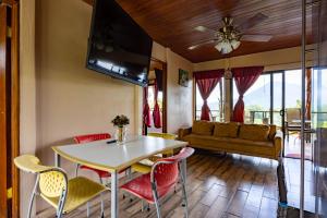 a living room with a table and chairs and a couch at Lua Pele House - Arenal Volcano & Lake views in El Castillo de La Fortuna