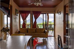 a living room with a couch and a table at Lua Pele House - Arenal Volcano & Lake views in El Castillo de La Fortuna