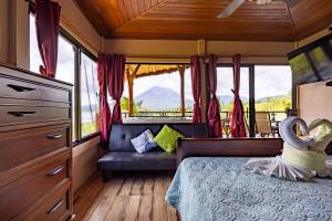 a bedroom in a rv with a bed and windows at Lua Pele House - Arenal Volcano & Lake views in El Castillo de La Fortuna