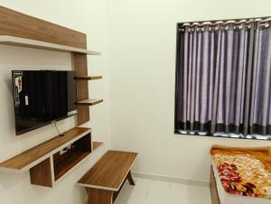 a living room with a tv and a couch at Shree Vishwakarma place in Khātu