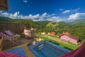 a woman sitting in a tub on a deck with a view of a mountain at Pousada Lua de Minas in Visconde De Maua