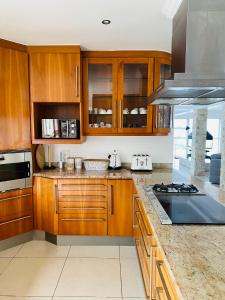 a kitchen with wooden cabinets and a stove top oven at De Ocean Lane Guest House in Cape Town