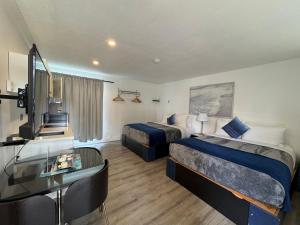 ein Hotelzimmer mit zwei Betten und einem Schreibtisch in der Unterkunft Riverside Resort & RV Park in Qualicum Beach